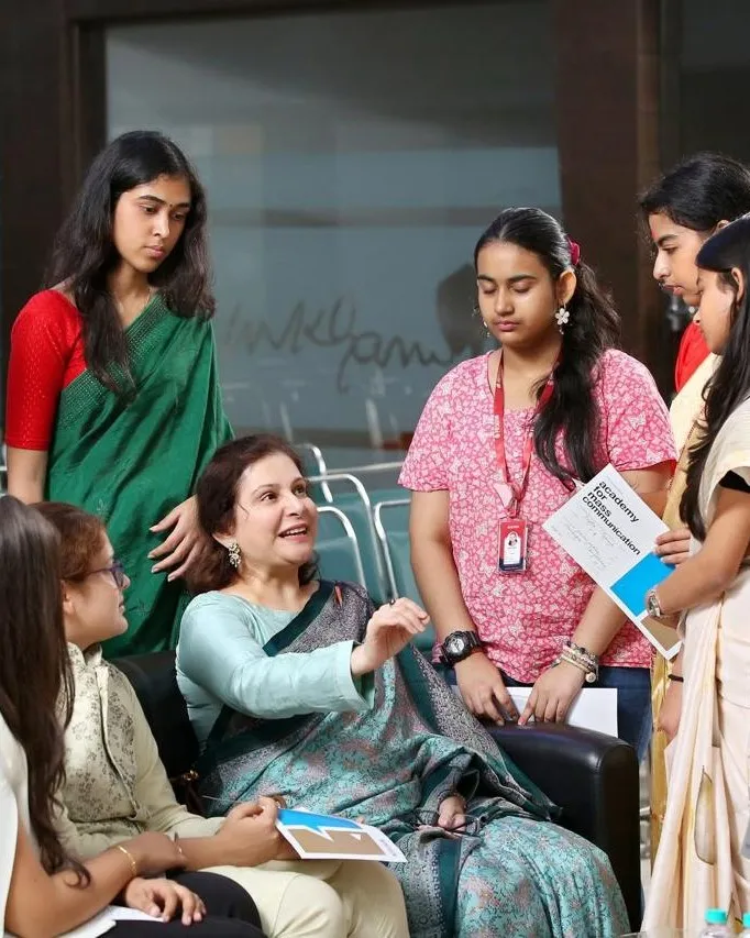 Shefali Chopra seated among a circle of students, mid-conversation